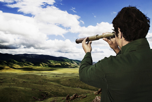 Man using telescope in field