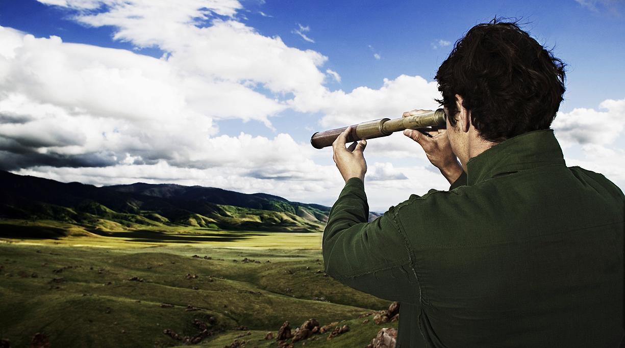 Man using telescope in field